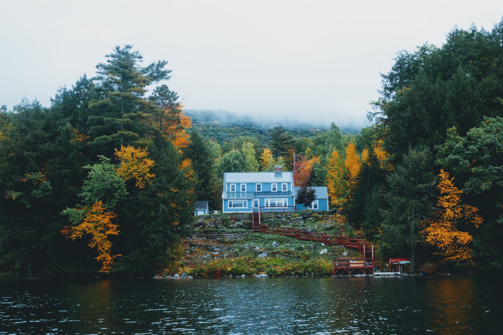 A body of water with a house and foliage in vermont